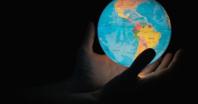 blue and brown globe on persons hand