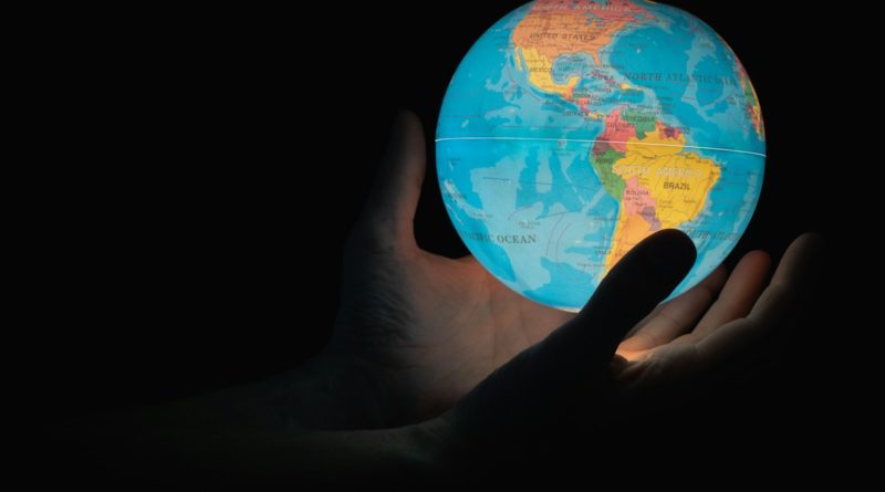 blue and brown globe on persons hand
